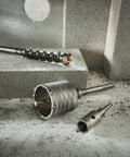 Beefy SDS Max Rotary Hammer Core Bit 4 In By 12 In With Wave Design and carbide centering tip on concrete surface