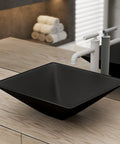 Claire 15.5 Inch Black Glass Vessel Sink for above counter mount with white faucet, showcasing sleek modern style in bathroom.
