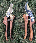 Two Heavy Duty Garden Pruning Shears With Japanese SK4 High Carbon Steel Blade for sharp cuts, wood grain handles on grass.