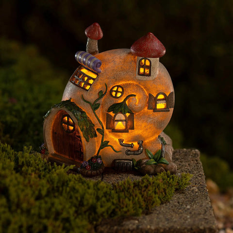Snail Shell Fairy Cottage Solar Powered LED Light for Outdoor Decor, flickering garden ornament on mossy surface.