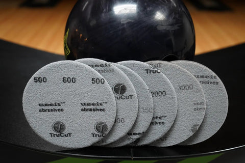 Bowling Ball Sanding Pads 6 Pack All Grits 500 1000 1500 2000 3000 5000 Resurfacing Set displayed on a bowling lane