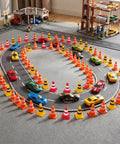 Mini traffic cones in bright colors surround a toy race track where colorful cars are racing. Kick Off Your Events With These Durable Mini Traffic Cones Bulk Pack Designed For Birthday Parties Classroom Drills And Hobby Track Layouts Ready To Roll Anytime Featuring Bold Assorted Colors Straight Up Tough Build.