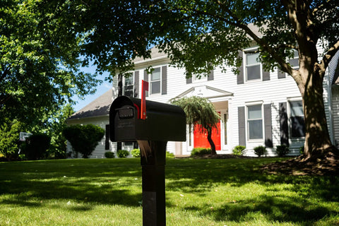 Cast Aluminum Heavy Duty Adjustable Mailbox Post Black With Weatherproof Powder Coat Finish Resists Rust Height From 33 To 41 Inches Supports Up To 120 Lbs Fits Over 4x4 Post CP000B00 in front of a house