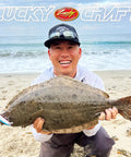 Angler holding halibut caught with FlashMinnow 110 Ghost Series Saltwater Jerkbait for Halibut and Bass on beach.