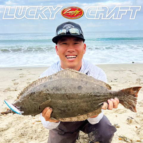 Angler holding halibut caught with FlashMinnow 110 Ghost Series Saltwater Jerkbait for Halibut and Bass on beach.