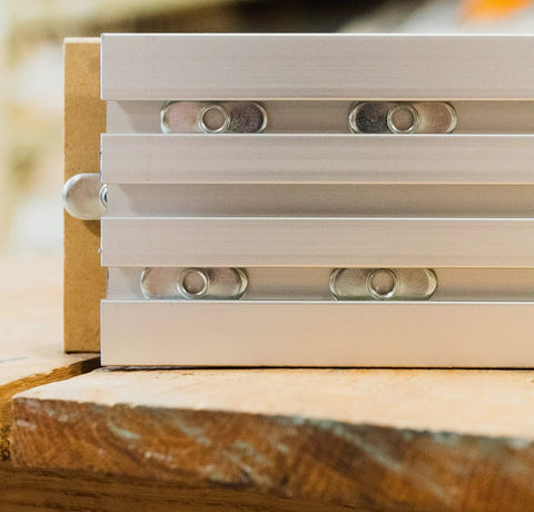 Pack Of 10 Zinc Plated T Track Nuts 1/4 20 Oval Nut Plates Fit Aluminum T Slot Extrusions on a wooden surface.
