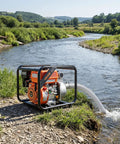 Heavy Duty Gas Powered Water Pump 2 Inch 142 GPM 7HP Portable Semi Trash Pump by a river for easy drainage and irrigation.