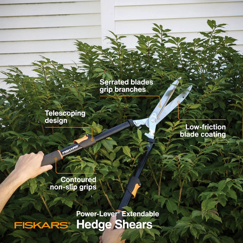 Extendable Hedge Shears With Power Lever For High Reach Pruning, Self Sharpening Serrated Steel Blades and adjustable handles over a bush.