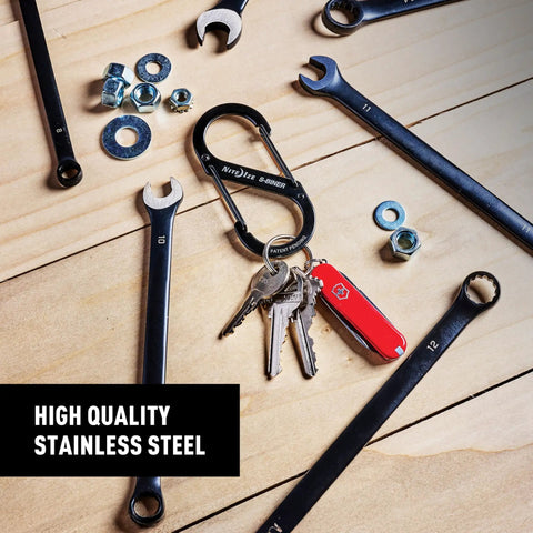 Stainless Steel Dual SBiner Clip Size 4 Tough As Nails Key Holder And Camping Gear Organizer with keys and tools on a wooden surface