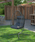 Egg Chair With Stand For Indoor Outdoor Use, Foldable Rattan Wicker Hanging Swing in a garden setting