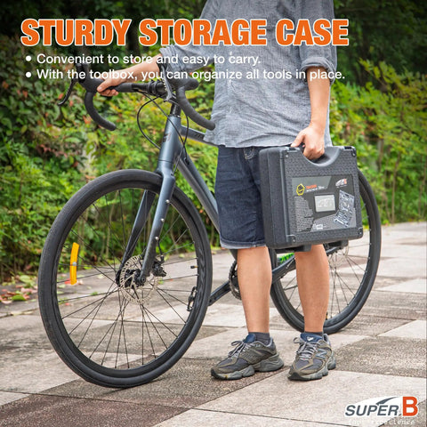 Person holding 30 Piece Bike Repair Kit With Carry Case For Road And Mountain Bikes next to bicycle outdoors.