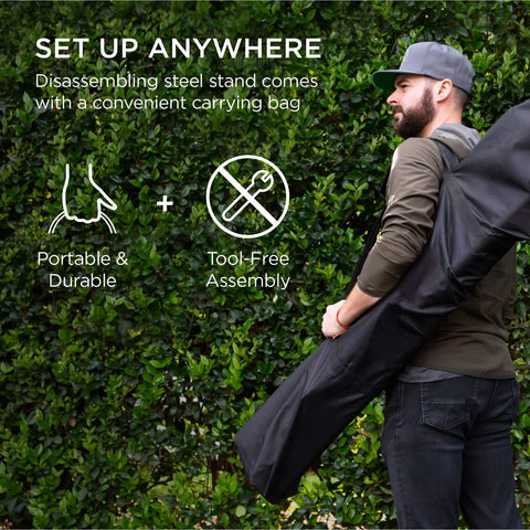 Man carrying Adjustable Portable Hammock Stand For 9 To 14 Ft Hammocks, Outdoor Patio Steel Frame in a black carrying bag