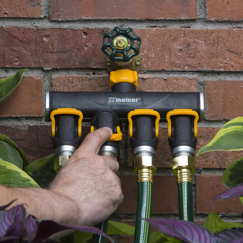 4 Way Lever Flow Through Valve Connector Bundle For Garden Hoses, High Volume Valves, Longer Levers, Vertical Operation, Metal Hose Threads, EZ Flow 4 Way Control, Yellow And Black on brick wall
