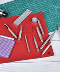 14-Piece Rivet Setter Kit For Leather Work Pro-Grade Stainless Steel Snap Rivet Tools with Non-Slip Base on red leather surface