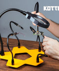LED Lighted Magnifying Third Hand Soldering Station with Five Adjustable Arms in use for holding PCB, bright LED lamp, yellow base.