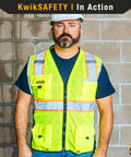 Big Kahuna Hi Vis Safety Vest Class 2 Orange Medium Featuring Super Comfy Breathable Mesh And Eleven Multi Utility Pockets Built Like A Tank For The Daily Grind And Heavy Duty Job Sites Nationwide, worn by a man in a construction setting.