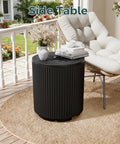 Black outdoor umbrella stand with fluted vertical ribbed design next to a patio chair, on round beige mat.