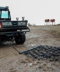 Rugged 6 Foot By 4 Foot Tow Behind Drag Harrow With Powder Coat Black Finish attached to ATV on soil field