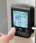 Dual Sensor Digital Oven Thermometer For Oven Grill And Smoker with programmable temperature display, being set on appliance.