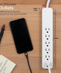 Six Outlet Surge Protector Power Strip Set for Home and Office Use with phone plugged in, UL listed, white.