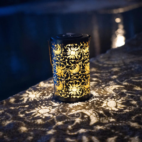 Outdoor Solar Lanterns For Garden Decor, hanging metal design with sun moon star lights on stone patio at night