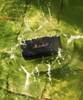 Emberton II Portable Bluetooth Speaker With 360 Degree True Stereophonic Sound, rugged black and brass in water splash.