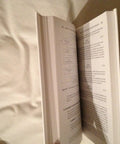 Book: Systems Engineering and Analysis, open pages with diagrams and dense text on a bed.