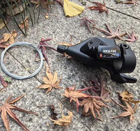 Right Side Seven Speed Bicycle Thumb Shifter With Gear Indicator on stone surface surrounded by autumn leaves