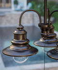 Close-up of Broadcast 3 Light Outdoor Chandelier In Oil Rubbed Bronze With Copper Highlight Finish, poolside view