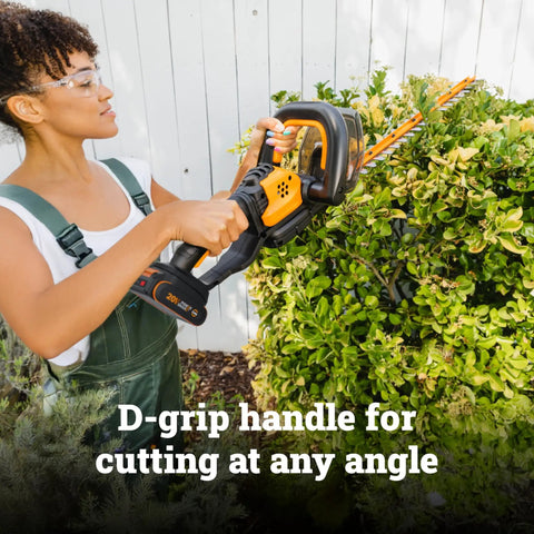 Person using 22 Inch Cordless Hedge Trimmer With Dual Action Blades on bushes, featuring D-grip handle for cutting
