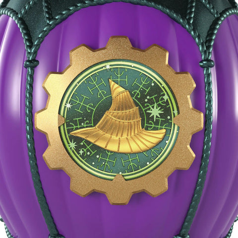 Close-up of purple balloon with a golden witch hat emblem from Unbox Wicked Ozian Balloons Reveal Toy Set With Surprise Mini Doll Inside Each Balloon Openable Balloons With Hot Air Basket And Accessory For Kids Creative Play And Collectible Fun Styles May Vary.