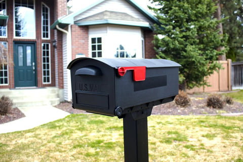 Patriot Large Capacity Rust Proof Plastic Post Mount Mailbox in Black with wide opening in front of a house
