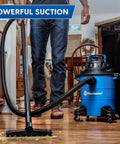 Person using 5 Gallon Wet And Dry Shop Vacuum With 3 Peak HP 65 CFM 16 Foot Reach Includes 8 Accessories With Cartridge Dry Filter And Foam Wet Filter VOC507PF Great For Home Or Shop Cleanup on kitchen floor.