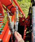 Hand holding hydraulic quick coupling pressure relief tool for half inch Pioneer ag poppet style fittings on tractor