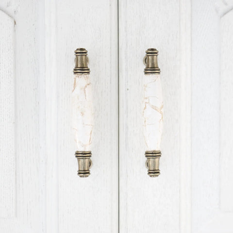 Solid As A Rock Cabinet Door Pulls Set Of Four Marble Ceramic Handles Heavy Duty Zinc Base Anti Rust Finish Easy No Sweat Install 3.78 Inch Center Spacing For Kitchen Hardware close-up of two bronze handles on white cabinet.
