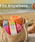 Patch Eco First Aid Kit tin in red with green label inside a beige tote bag on the beach