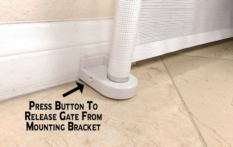 Base of Retractable Indoor Outdoor Pet Safety Gate For Doorways And Stairs Up To 54 Inches showing release button.