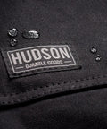 Close-up of black Heavy Duty Waxed Canvas Apron for Men and Women, Adjustable Crossback with Tool Pockets, water beads on fabric
