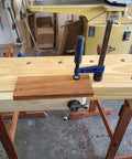 Quick-Adjust Vertical Workbench Hold Down Clamp For Three Quarter Inch Dog Holes gripping wood on workbench.