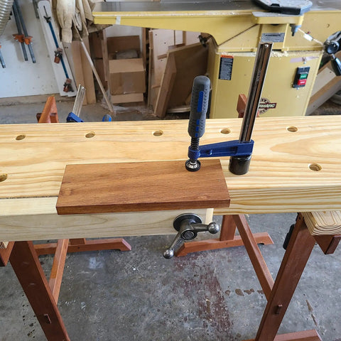 Quick-Adjust Vertical Workbench Hold Down Clamp For Three Quarter Inch Dog Holes gripping wood on workbench.