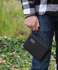 Person holding Travel Electronics Organizer Hard Shell Case With Water Resistant Zipper Durable Exterior 6.5 Inch in hand.
