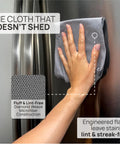 Hand using Stainless Steel Cleaning Cloths 8 Pack For Wiping Appliances And Surfaces With Just Water No Chemicals Safe For Food Prep Kids And Pets Streak Free Scratch Free Microfiber Restores Factory Shine For Home And Commercial Use on fridge