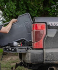 Person loading Stable Table Lite With Weatherproof Tabletop And Ambidextrous Seat into truck