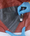 Applying Seam Grip WP Waterproof Sealant And Adhesive For Jackets Tents Tarps Rain Gear And Outdoor Fabric on a tent seam
