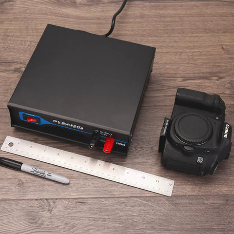 Powerful Bench Power Supply For Home Lab 30 Amp Regulated AC To DC Converter with camera and ruler on wood surface