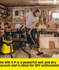 Person using WD 5 P Shop Vacuum 6.6 Gal Wet Dry Vacuum Cleaner with 33 Ft Reach in a workshop setting.