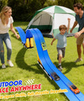Family playing with 16 Foot Flexible Race Track Set For Kids with Roll Up DIY Lanes on grass by a tent, showcasing outdoor fun.