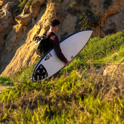 Surfer carrying board with 25L Waterproof Surf Backpack For Adventure With Roll Top Closure Keeps Gear Dry In Any Weather