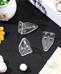 Crystal Clear Window Blind Hold Down Brackets No Sweat Mini Plastic Tension Clips For Roller Shades And Blinds Quick Setup Sturdy Home Hardware set of three clear clips on a black surface.