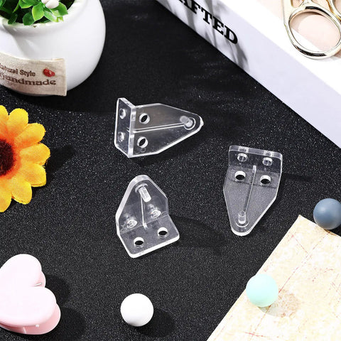 Crystal Clear Window Blind Hold Down Brackets No Sweat Mini Plastic Tension Clips For Roller Shades And Blinds Quick Setup Sturdy Home Hardware set of three clear clips on a black surface.